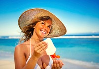 Smiling woman putting on sunscreen