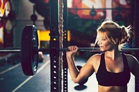 Blond woman lifting weights gym