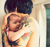 Tattooed father caring for his baby daughter