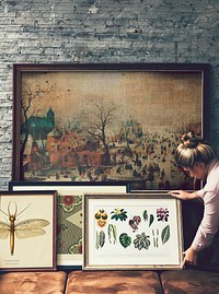 Woman arranging picture frames and art