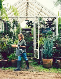 Woman tending to plants in a greenhouse