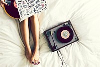 Woman listening to music from a vinyl disk turntable