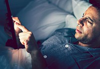 Man using his phone in bed