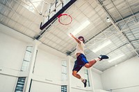 Young basketball player making a slam dunk