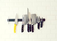 Set of knives hanging on a white wall