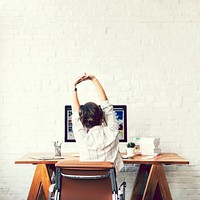 Designer stretching in front of her computer