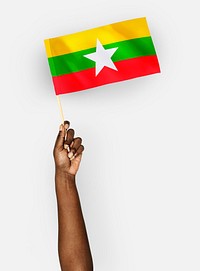 Person waving the flag of Republic of the Union of Myanmar