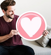 Cheerful man holding heart icon