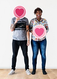 Interracial couple holding valentine&#39;s icons