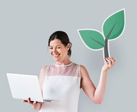 Woman holding a plant icon and using a laptop