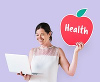 Woman holding a health icon and using a laptop