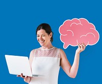 Woman holding a brain icon and using a laptop