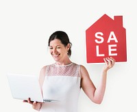 Woman holding a house sale icon and using a laptop