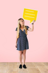 Cheerful woman holding a yellow speech bubble