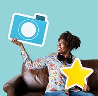 Cheerful woman showing blue camera icon on couch