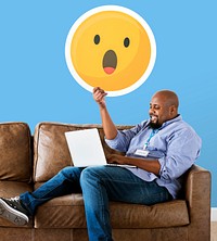Man showing a surprised emoticon and using laptop