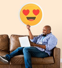 Man showing heart eyes emoticon on couch