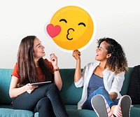 Cheerful women holding a kissing emoticon icon