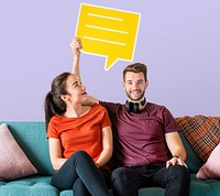 Cheerful couple holding a yellow speech bubble icon