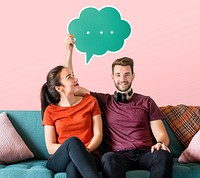 Cheerful couple holding a green speech bubble icon