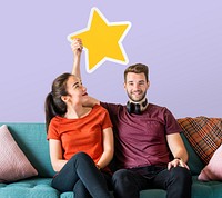 Cheerful couple holding a golden star icon