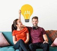 Cheerful couple holding a light bulb icon