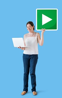 Standing woman holding a play button and a laptop