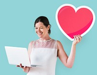 Woman holding a heart emoticon and a laptop