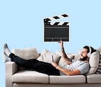 Male on a couch holding a clapper icon