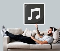 Male on a couch holding a musical note icon<br />