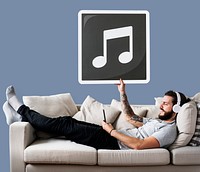 Male on a couch holding a musical note icon<br />