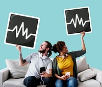 Interracial couple on a couch holding frequency icons