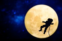 Spaceman silhouette over a full moon