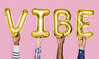 Yellow gold alphabet balloons forming the word vibe
