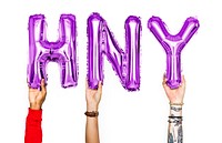 Hands holding balloons spelling HNY