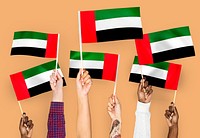 Hands waving flags of the United Arab Emirates