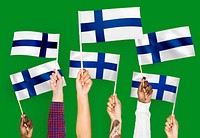 Hands waving flags of Finland