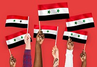 Hands waving flags of Syria