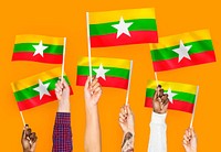 Hands waving flags of Myanmar