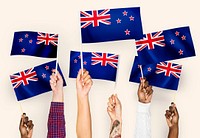 Hands waving flags of New Zealand