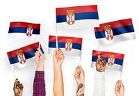 Hands waving the flags of Serbia
