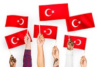 Hands waving flags of Turkey