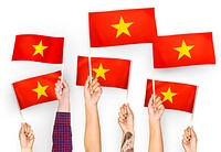 Hands waving flags of Vietnam