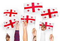 Hands waving flags of Georgia