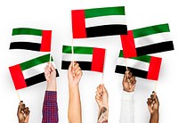 Hands waving flags of the United Arab Emirates