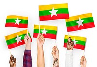 Hands waving flags of Myanmar