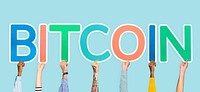 Hands holding up colorful letters forming the word bitcoin
