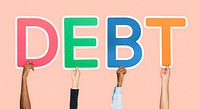 Hands holding up colorful letters forming the word debt