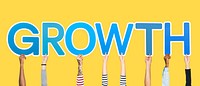 Hands holding up blue letters forming the word growth