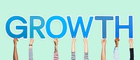 Hands holding up blue letters forming the word growth